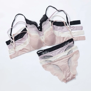 Detailed flat lay of French lace lingerie sets in black, lavender, cream, and pink