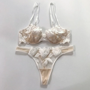 Detailed close-up of white floral lace lingerie set with mesh embroidery and underwire