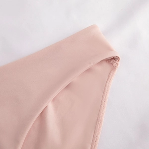 Close-up of seamless stitching and smooth fabric edge on a pink lace-free bra