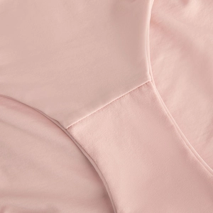 Close-up of fine rib-knit pink lingerie fabric with smooth seam details and clean finish