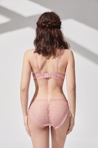 Detail view of pink sheer lace bra back closure and heart pattern panty on a model