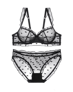 Detail of sheer black mesh lingerie set with flocked heart patterns and ruffled edges