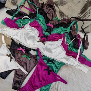 Detailed view of satin lace lingerie sets with heart trim and bow details in various colors