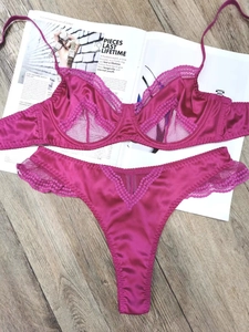 Detail view of pink satin lingerie set with floral lace trim and underwire cups