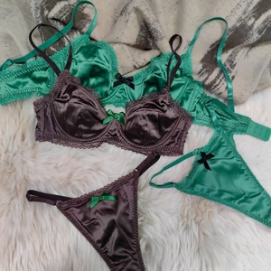 Flat lay of satin lace lingerie sets in green and brown with delicate bow details