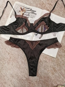 Détails de l'ensemble de lingerie en satin noir et dentelle brune sur un magazine de mode