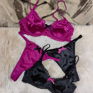 Detailed view of satin bra and thong set with lace trim and bow on plush white fur