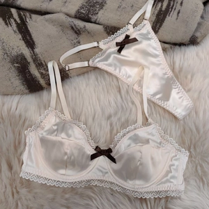 Detailed view of satin and lace lingerie set with heart patterns and brown bows