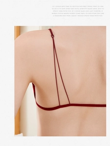 Detail of burgundy minimalist backless bra featuring thin elastic straps and sleek design