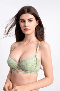 Detail of light green floral lace bra showing delicate hollow straps and metal ring accents