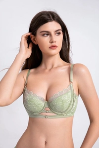 Détail d'un soutien-gorge en dentelle vert clair avec anneau en métal et broderie