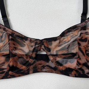 Detail of leopard print sheer mesh bra with adjustable black straps and gold hardware
