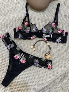 Detail view of black sheer mesh bra with pineapple embroidery and wavy lace edges