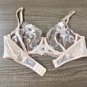 Close-up of floral embroidery on sheer mesh cups with adjustable straps and steel support