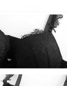 Dettaglio del body in pizzo nero con fiocchi di raso e trama floreale complessa