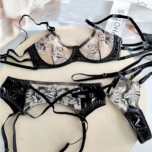 Detail shot of black faux leather and mesh lingerie set with white floral embroidery