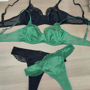 Flat lay detail of lace lingerie sets in black and emerald green with satin mesh