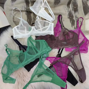 Flat lay of sheer lace lingerie sets in white, green, purple, black and brown colors
