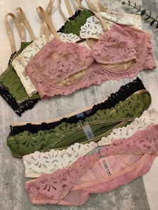 Dettaglio di completi intimi in pizzo in rosa, beige, verde e nero con etichette tessili