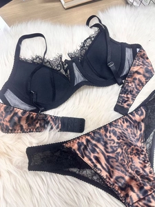 Detail of leopard print lingerie set with black lace trim on soft faux fur background