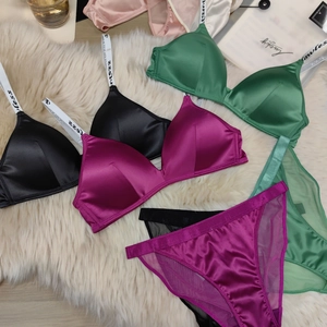 Detail view of satin wire-free bras in black, green, and pink with Lawless logo straps