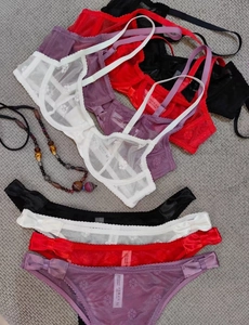Detailed pile of sheer lace lingerie sets in white, purple, red, and black floral mesh