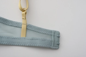 Detail of light blue mesh side wings and adjustable yellow straps on a soft-cup bra