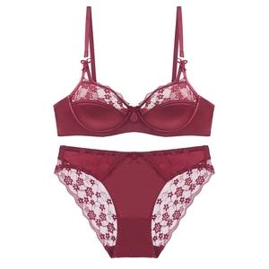 Detailed view of wine red lace lingerie set with silk fabric and delicate bow accents
