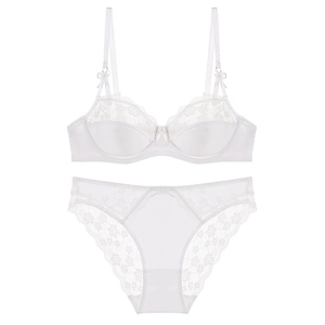 Detail of white lace lingerie set featuring delicate silk cups and floral embroidery accents