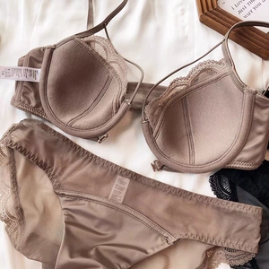 Detailed flat lay of brown lace bra and panties set with clear wash care labels