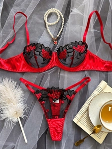 Dettaglio dell'intimo in pizzo ricamato rosso con perle e accessori decorativi