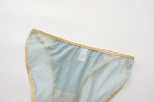 Close-up of light blue mesh panties with beige elastic trim and breathable fabric texture