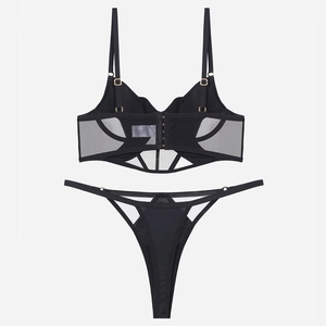 Dettaglio del set lingerie in rete nera trasparente con stecche e fibbie dorate regolabili