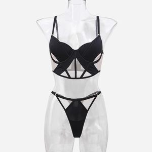 Dettaglio del set reggiseno a corsetto in rete nera e perizoma con lacci e trasparenze