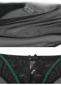 Close-up of black lace underwear featuring green trim and a delicate bow detail