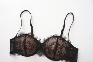 Détail de soutien-gorge en dentelle de cils noire avec motifs floraux et petit nœud