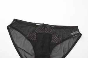 Detail view of black mesh lace panties with purple glitter diamond pattern and a bow