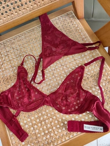 Gros plan sur un soutien-gorge en dentelle bordeaux avec étiquette de lavage taille M