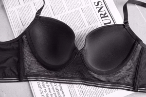 Detail of black seamless push-up bra with lace side wings and adjustable straps