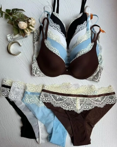 Présentation à plat de quatre soutiens-gorge push-up en dentelle et culottes assorties