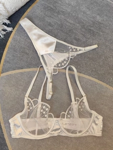 Détail d'un ensemble de lingerie blanche en dentelle avec broderie et étiquette