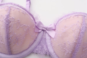Gros plan sur un soutien-gorge en dentelle violette avec un petit nœud décoratif chic