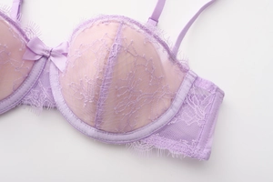 Détail d'un soutien-gorge en dentelle lilas avec motifs floraux et bordure en dentelle