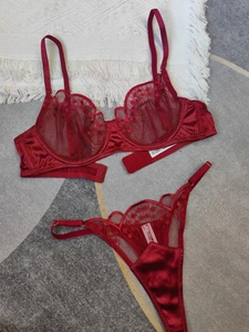 Vue détaillée d'un ensemble de lingerie en dentelle rouge avec broderies et finitions satin