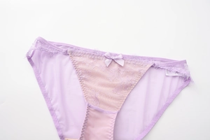 Détail de culotte en dentelle lavande avec nœud et bordure en dentelle cil fine