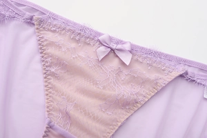 Détail de la dentelle cil lilas et du tissu en maille avec un nœud en satin