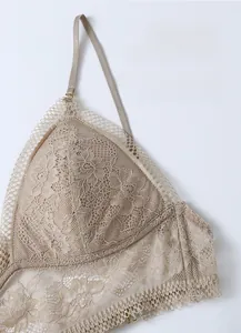 Detailed close-up of French floral lace texture and eyelash trim on beige bralette