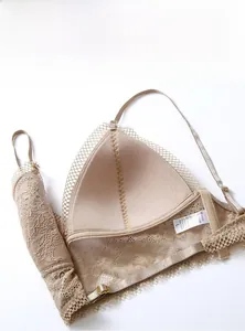 Detail view of foldable beige lace bralette showing its soft, wireless mesh material