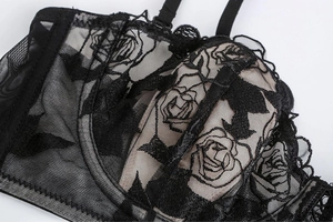 Close-up of black lace bra featuring delicate rose floral embroidery and sheer mesh texture