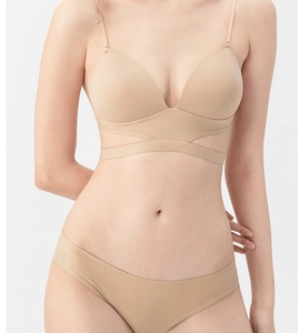 Detail view of skin-tone seamless lingerie set with crisscross bands and mesh panels